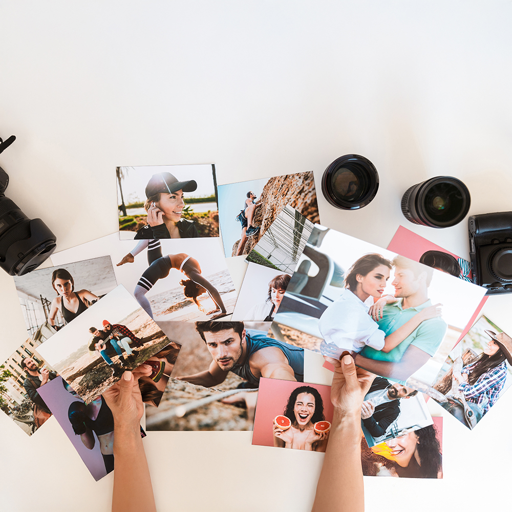 Photographer woman in office sit at the table looking at photos.